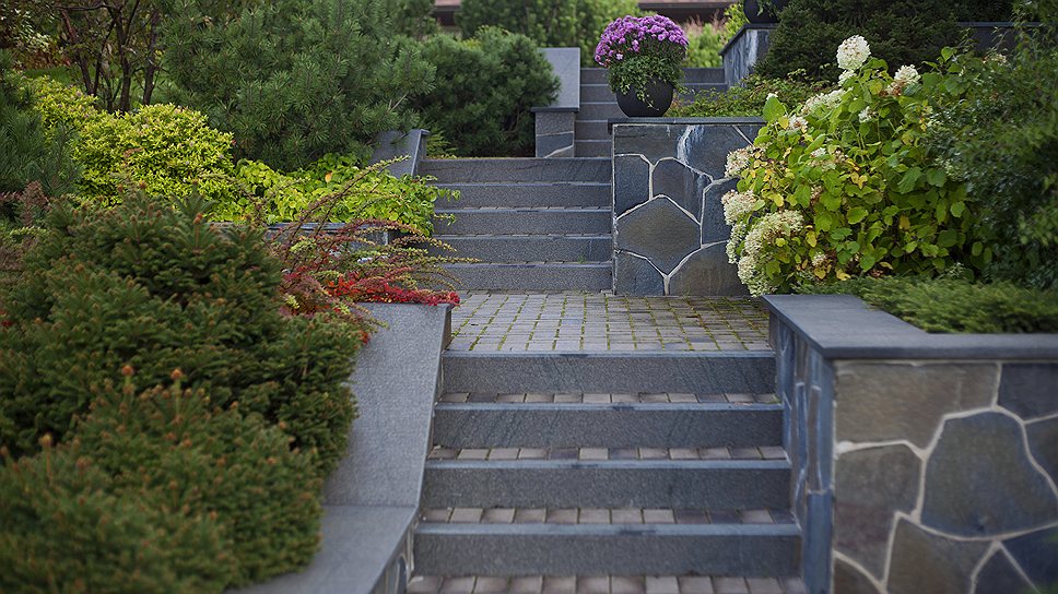 Перепад рельефа «обыгран» нарядной лестницей из термообработанного гранита, украшенной цветущими растениями
