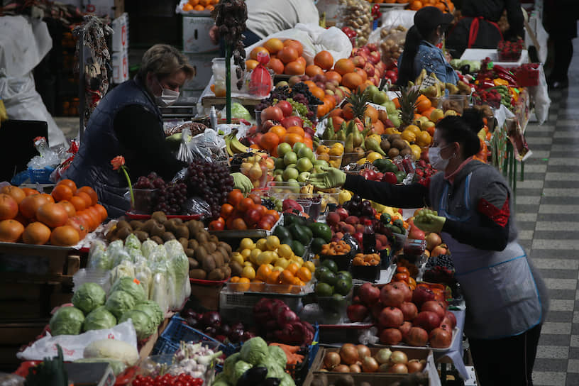 Продавщицы овощей в медицинских масках на рынке
