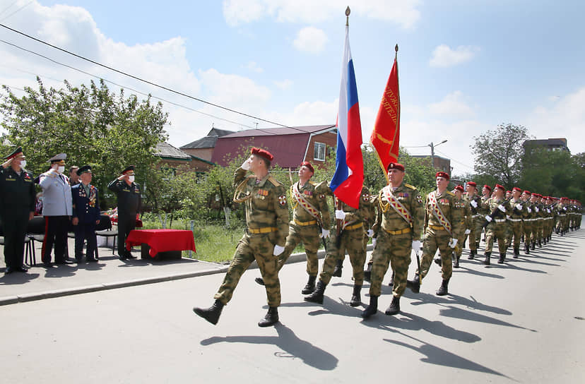 Ростов-на-Дону во время режима самоизоляции из-за опасности распространения коронавирусной инфекции COVID-19. Празднование 75-ой годовщины Победы в Великой Отечественной войне. Ветеран Великой отечественной войны Петр Голышкин (второй справа) во время торжественного марша парадного расчета росгвардейцев перед домом ветерана.