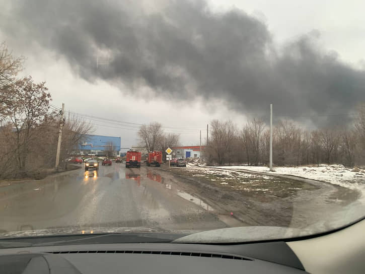 На подъезде к охваченному огнем промышленному объекту выстроились пожарные машины