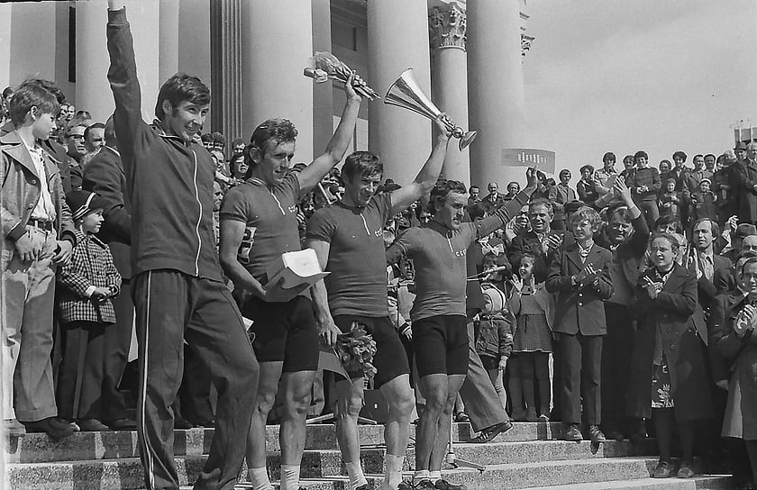 Группа спортсменов с кубками и грамотами на фоне театра. Фасад использовался как символ города для официальных фотографий