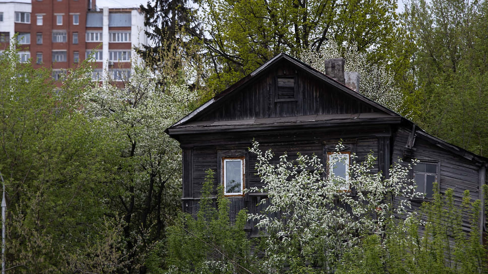 Деревянный дом на фоне цветущих деревьев