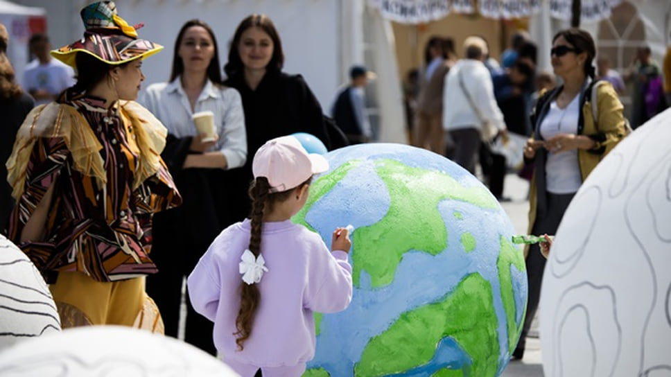 Девочка, разукрашивающая макет Земли