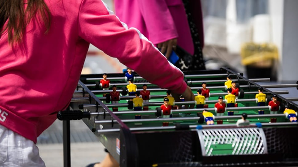 Девочка, играющая в настольный футбол