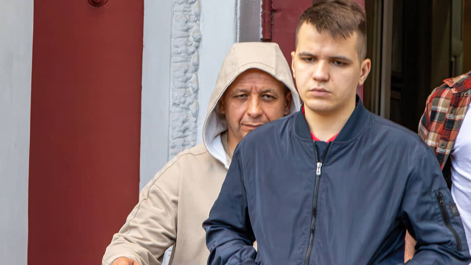 Евгений Катюшкин выходит из здания суда (слева в капюшоне)