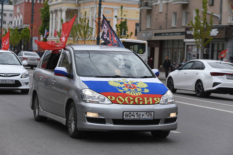 Колонна автомобилей с флагами во время праздничного автопробега по улицам Воронежа