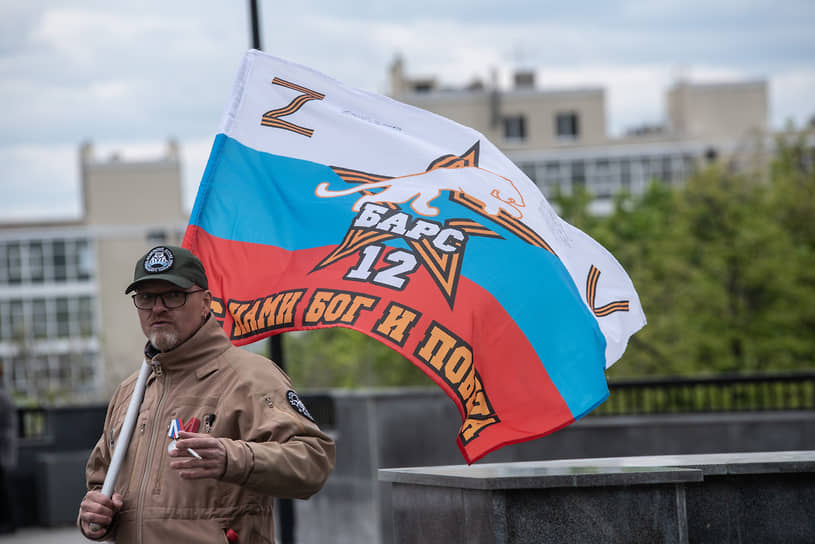 Мужчина с флагом добровольческого отряда «Барс-12», действующего в Луганской народной республике