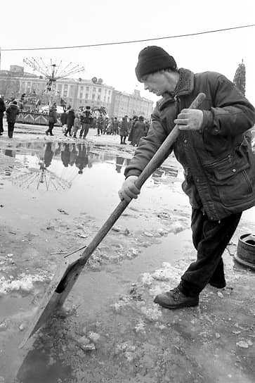 Дворник убирает воду на площади Ленина. Декабрь 1998 года