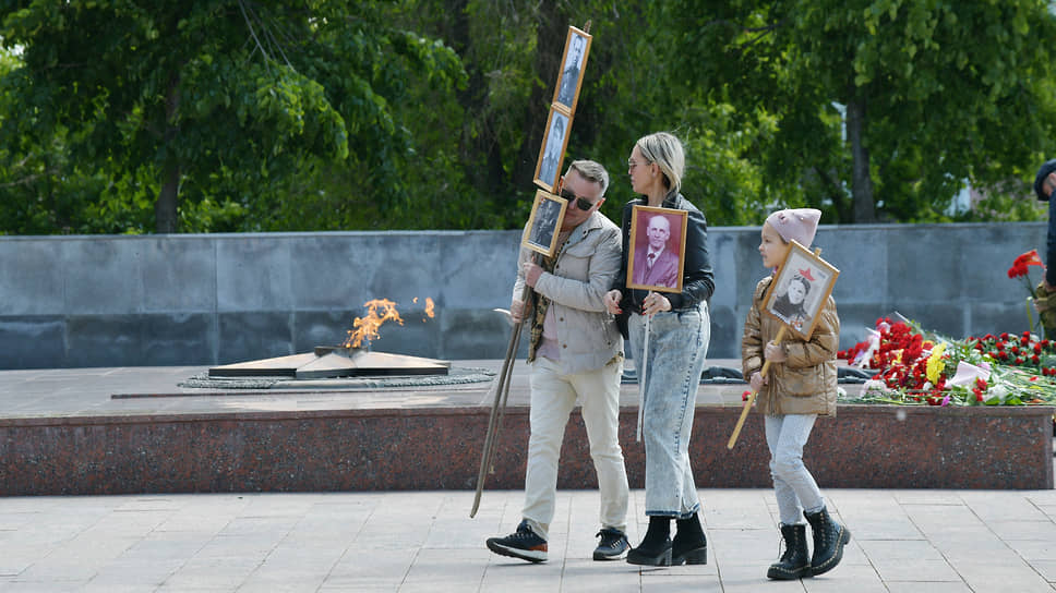 Семья с портретами родственников — участников Великой Отечественной войны у вечного огня на площади Победы