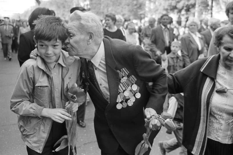 Ветеран Великой Отечественной войны целует мальчика, подарившего ему цветы, во время праздничного шествия по проспекту Революции в Воронеже. Май 1998 года