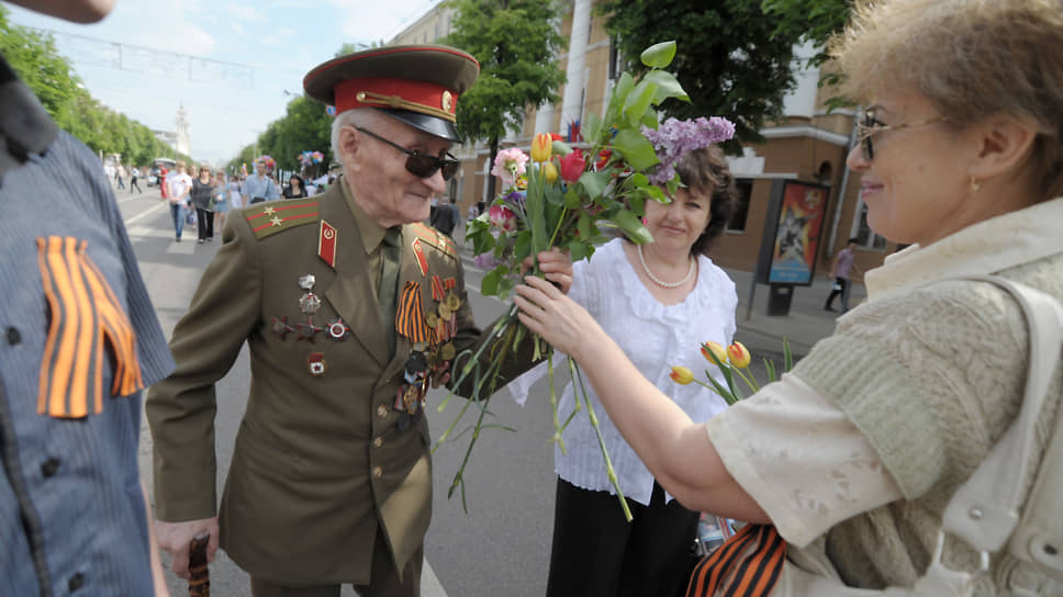 Жители города дарят цветы ветерану Великой Отечественной войны во время праздничных гуляний на проспекте Революции в Воронеже. 2012 год