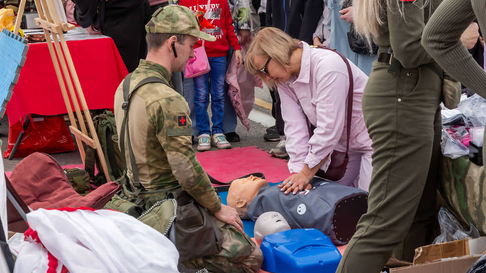 Женщина под руководством военного специалиста-медика обучается оказанию медицинской помощи