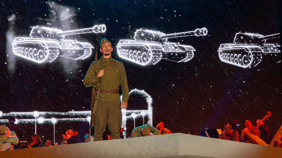 Один из солистов концерта в военной форме с винтовкой