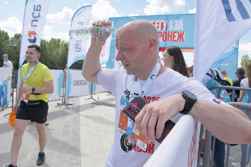 Участник соревнования после финиша обливается водой