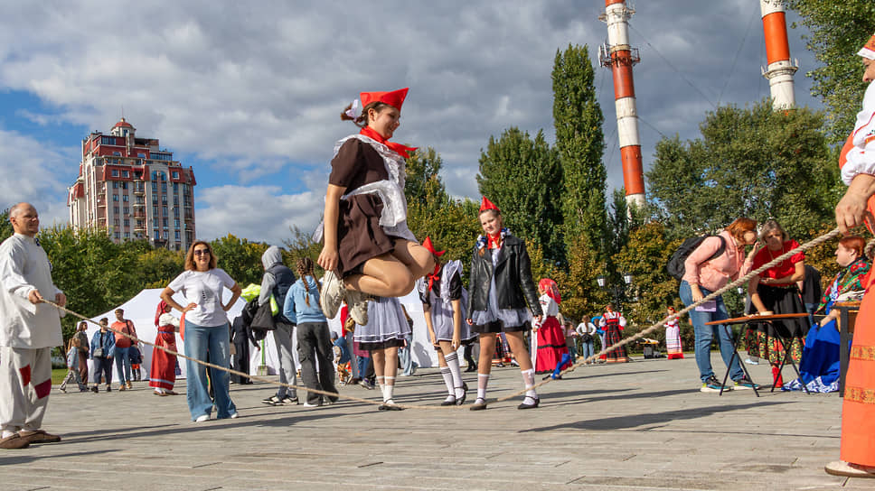 Девушка в костюме пионерки прыгает через канат на Дне города в Воронеже