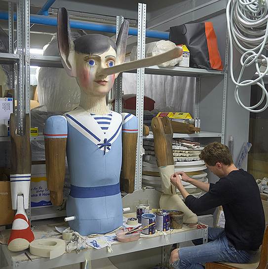 Декоратор заканчивает работу над скульптурой Пиноккио 
